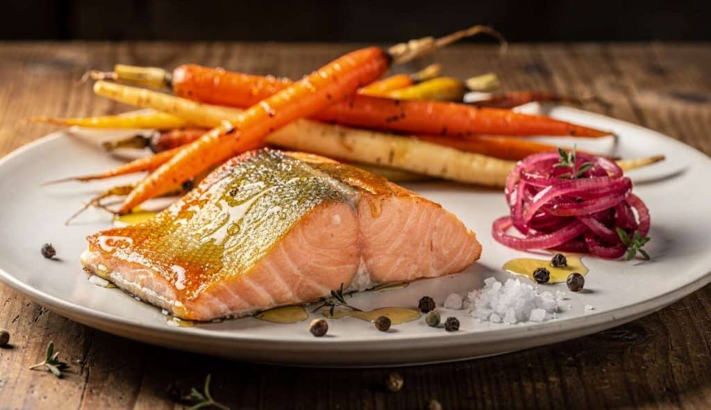 Pavé de saumon à l'unilatérale, racines confites et pickles d'oignons rouges - Recette gourmande